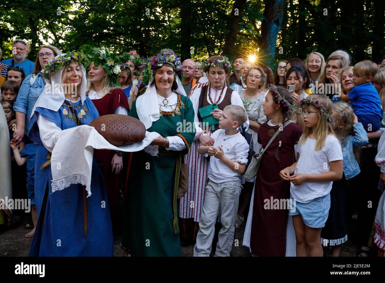 Frauen in litauischen Nationalkostümen führen während des Mittsommerfestivals in Vilnius Rituale mit frisch gebackenem Roggenbrot durch Stockfoto