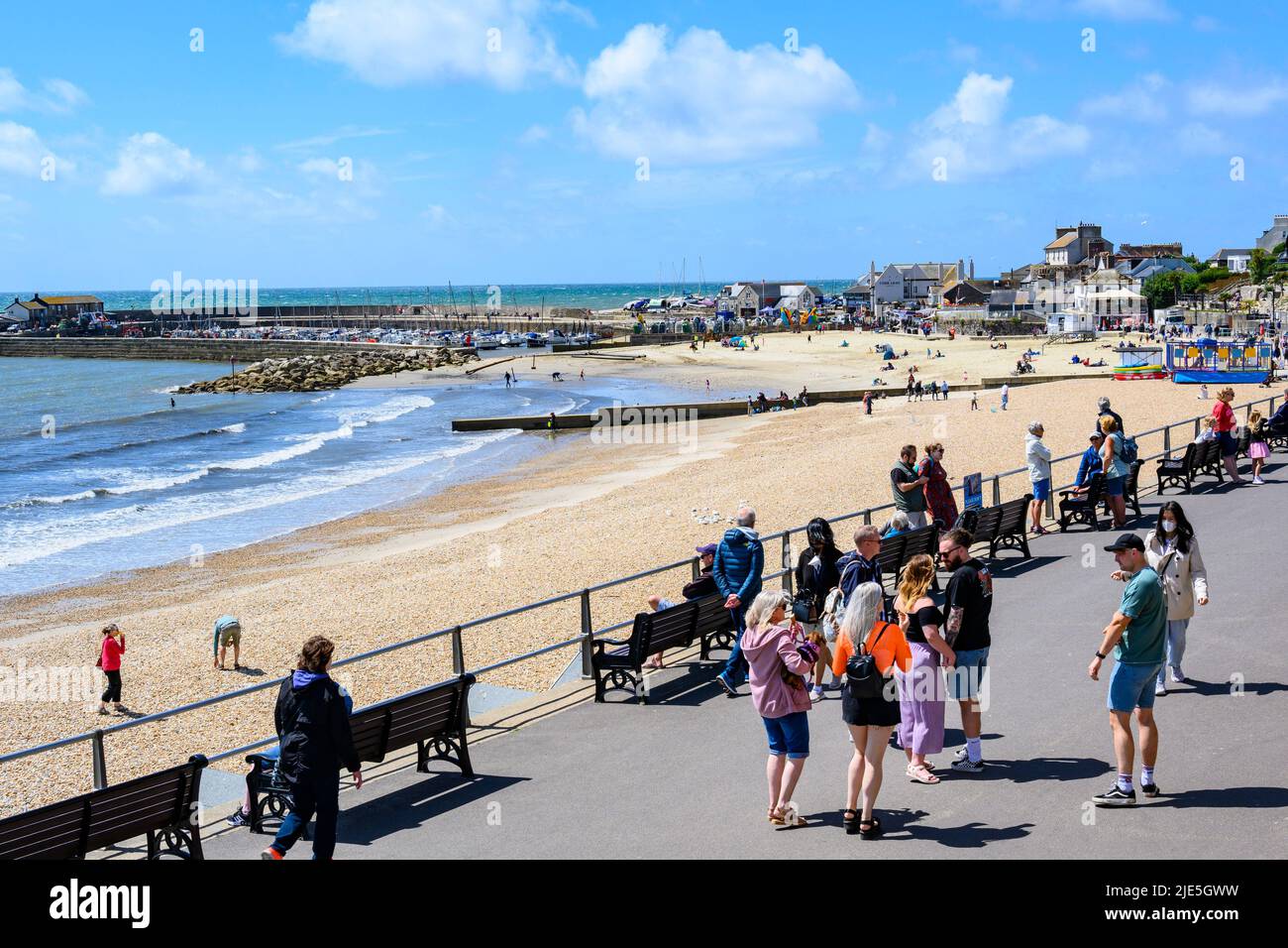 Lyme Regis, Dorset, Großbritannien. 25.. Juni 2022. Wetter in Großbritannien: Besucher und Einheimische machen das Beste aus heißen, sonnigen Zaubersprüchen an einem warmen, aber stürmischen Tag im Badeort Lyme Regis. Es wird erwartet, dass die Sonne später bricht, da Regen und Gewitter aus dem Westen kommen und feuchtere und wechselhaftere Bedingungen bringen. Kredit: Celia McMahon/Alamy Live Nachrichten Stockfoto