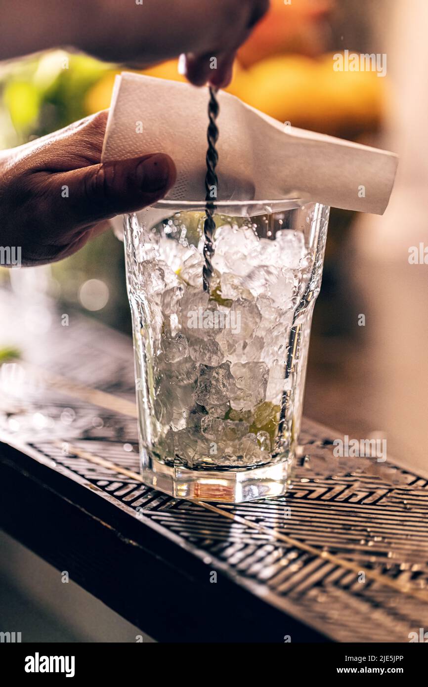 Professioneller Barkeeper, der Cocktails an der Theke zubereitet Stockfoto