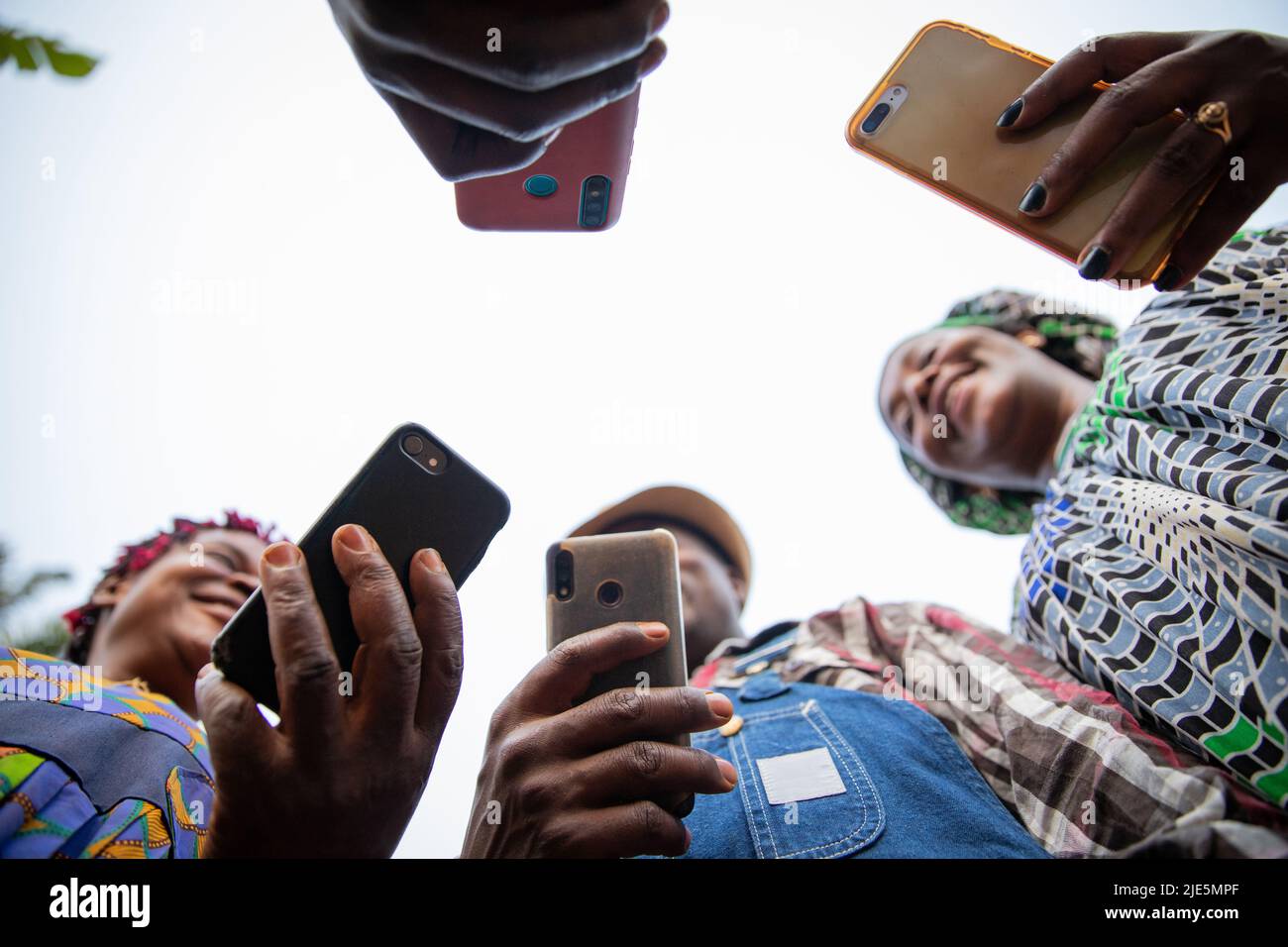 Eine Gruppe afrikanischer Menschen nutzt ihre Smartphones, Fotos von unten, Technologie und soziale Netzwerke in afrika Stockfoto