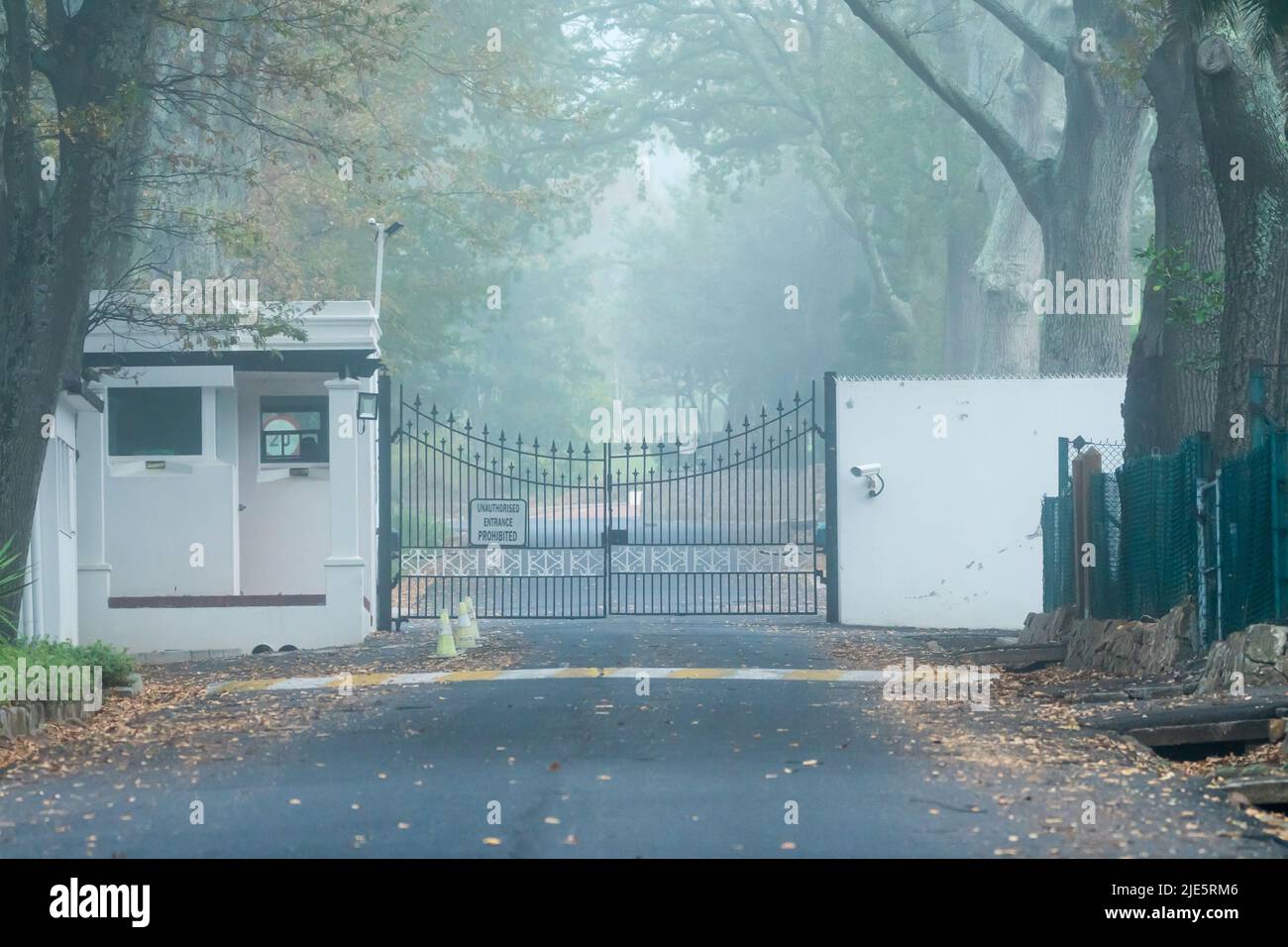 Hohe Sicherheit mit Polizeiwache oder Wachhaus und geschlossenen Metalltoren an Sicherheitskontrollstelle in Kapstadt, Südafrika Stockfoto