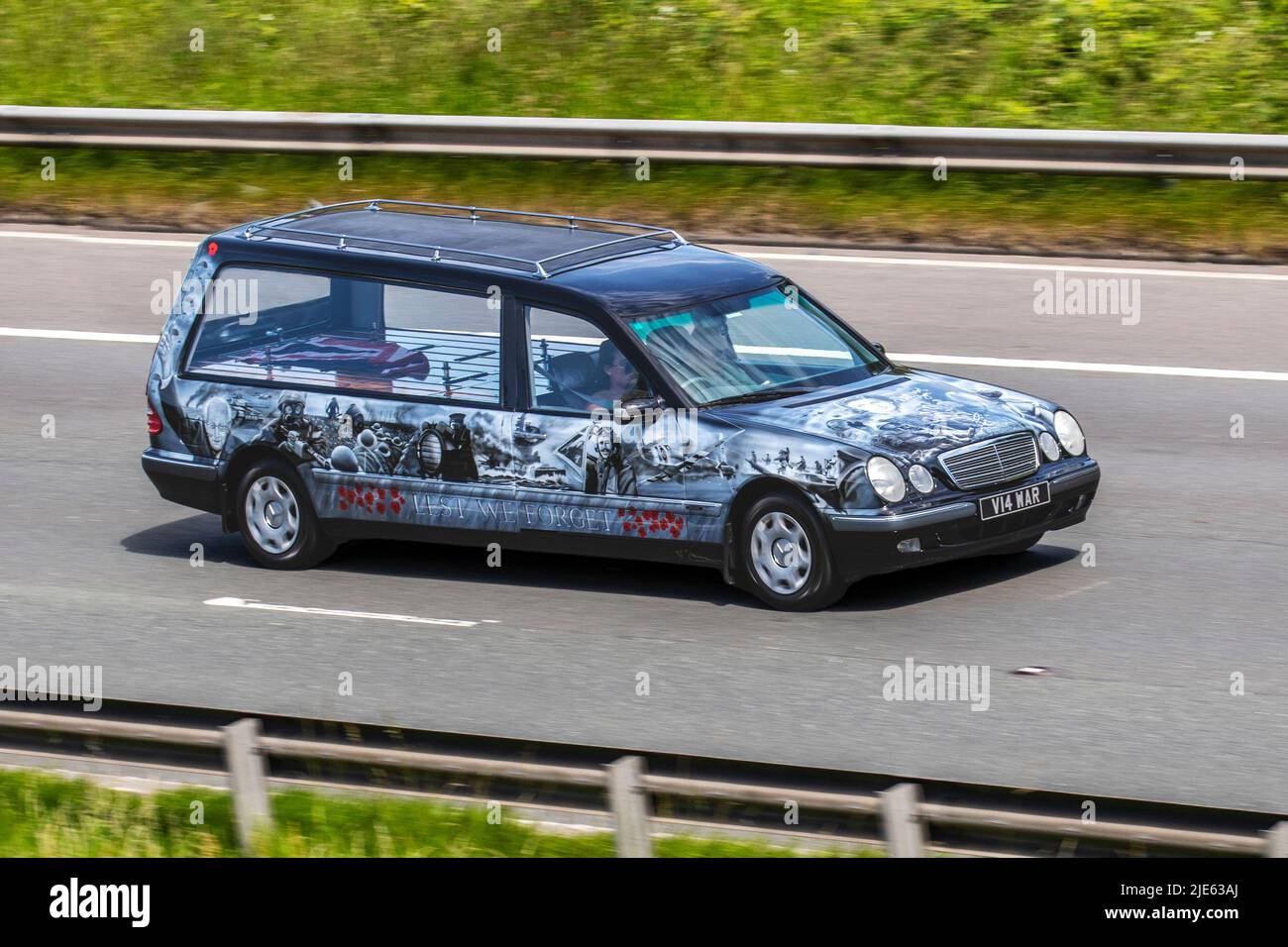 'Lest We Forget' British Union Jack Funeral Custom Hearse; 2000 deutscher Mercedes Benz E E240 Avant Garde schwarz. 2. Weltkrieg, 2. Weltkrieg, 2. Weltkrieg, WW2, Gedenkkunstwerke. Spezialfahrzeuge auf dem Weg nach Manchester UK Stockfoto