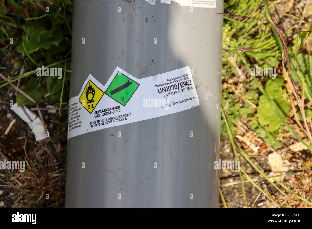 Gasflaschen mit Lachgas und schwarzen Ballons wurden nach der Einnahme als Drogen in Den Haag auf dem Parkplatz gelassen Stockfoto