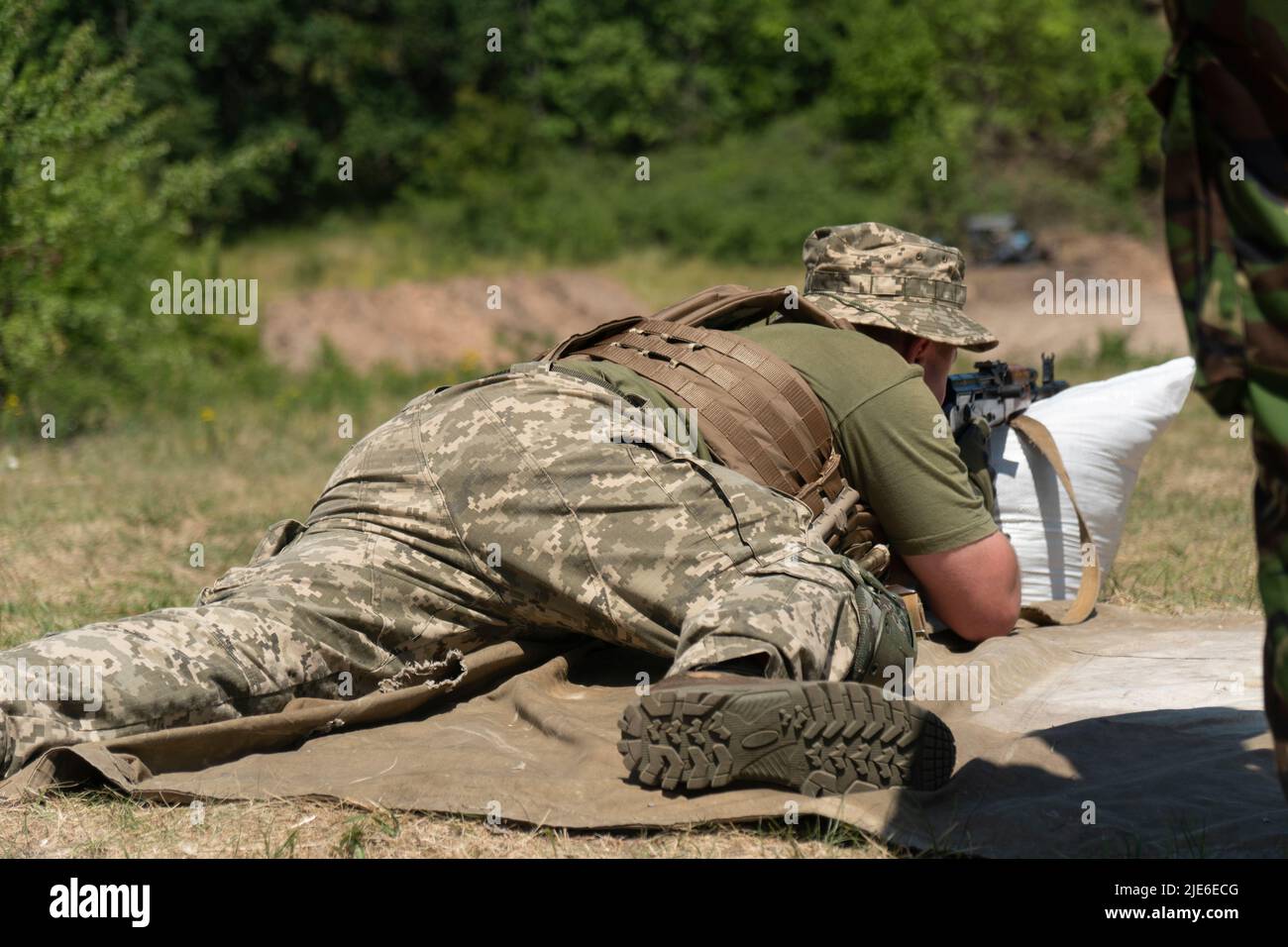 Das ukrainische Militär feuert aus einem Maschinengewehr. Stockfoto