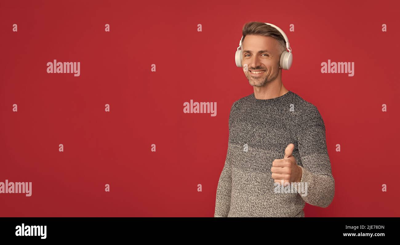 Die besten Lieder, die Sie je hören können. Glücklicher Mann, der sich die Daumen hoch für die Musik macht. Melodie Stockfoto