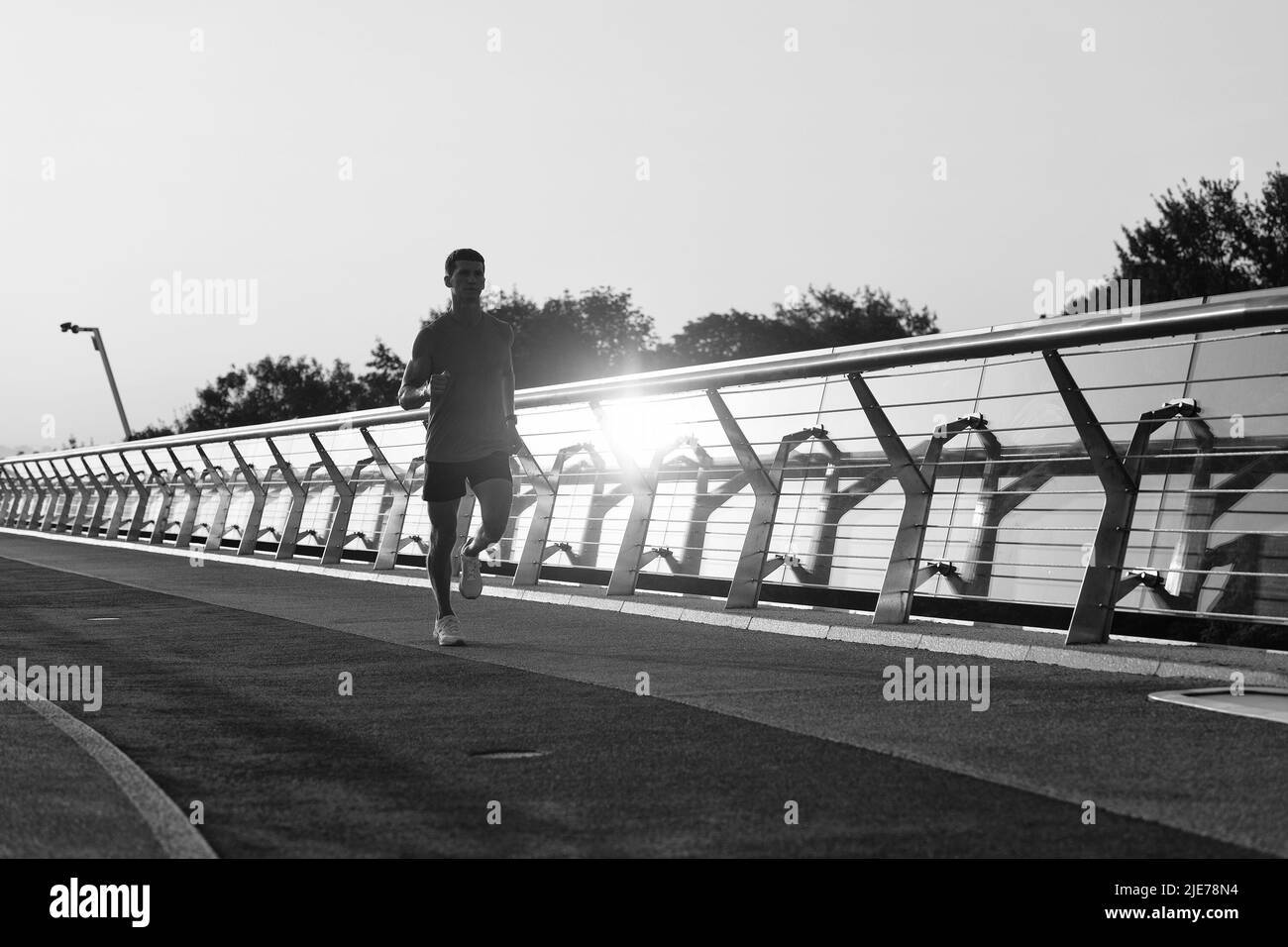 Abendlauf. Der sportliche Typ läuft auf der Promenade. Laufmännchen. Abendläufer. Joggingaktivitäten Stockfoto
