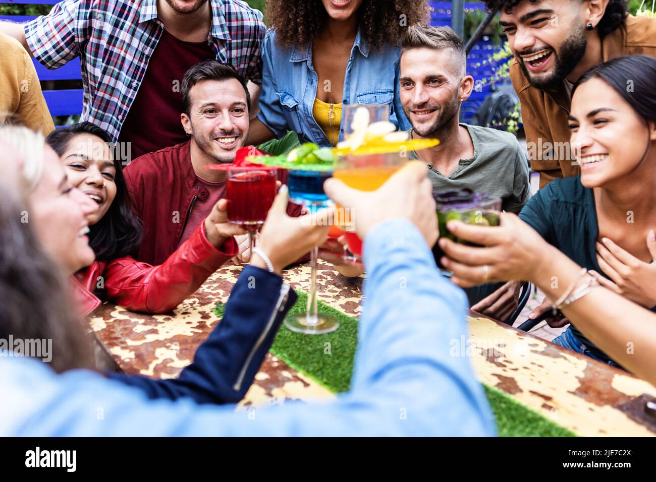 Eine Gruppe von Menschen aus verschiedenen Rassen jubelt mit trendigen Cocktails im Brauerei Pub Stockfoto