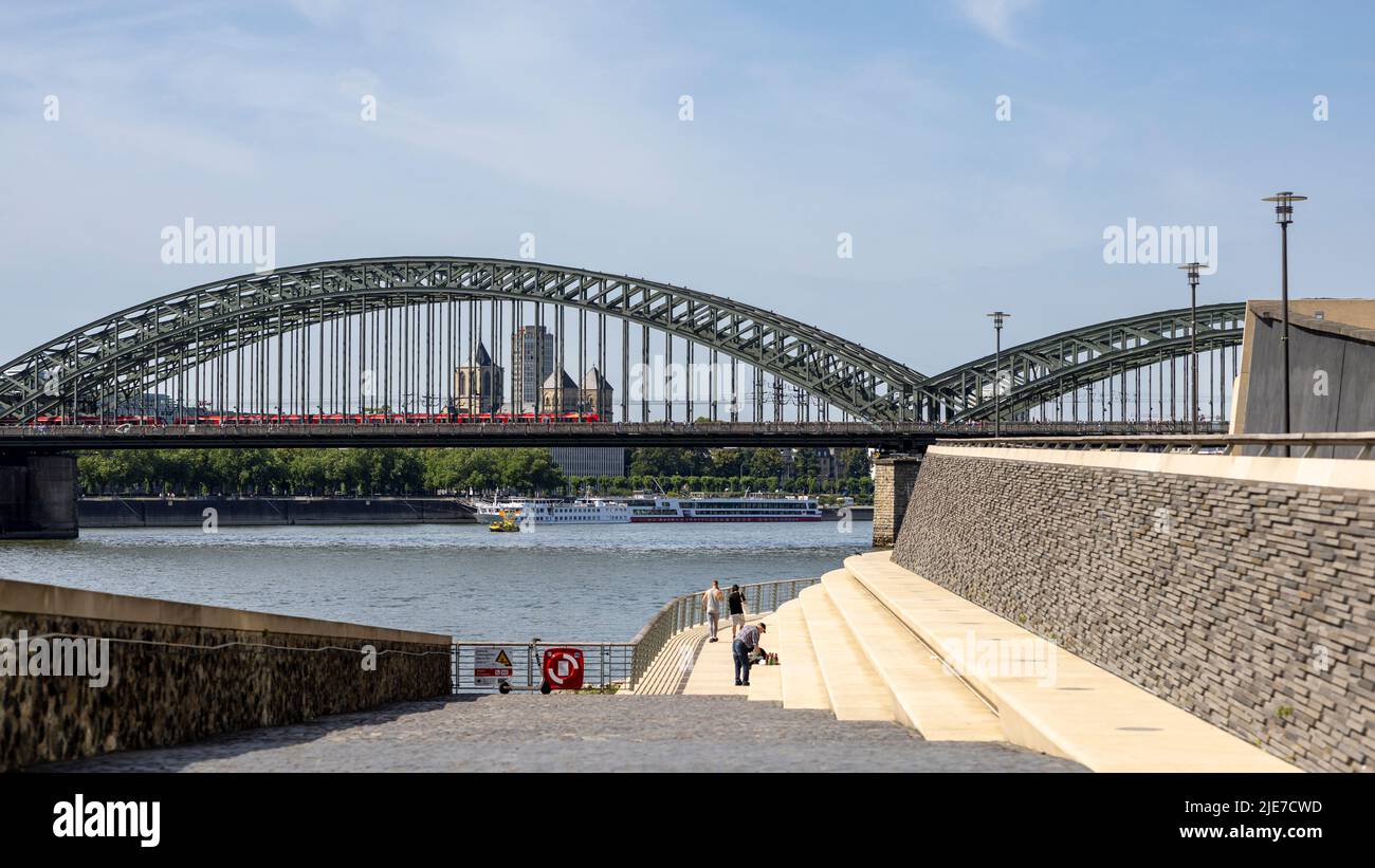 Menschen verbringen einen warmen Tag am Rheinufer in Köln Stockfoto