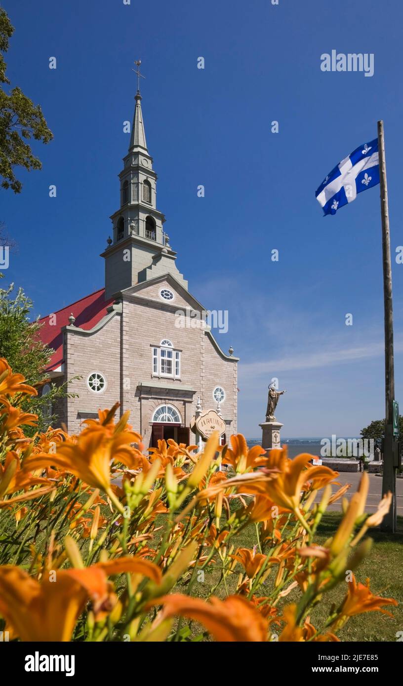 Saint-Jean Kirche durch orange Hemerocallis - Taglilien Taglilien im Sommer, Saint-Jean, Ile d'Orleans, Quebec, Kanada. Stockfoto