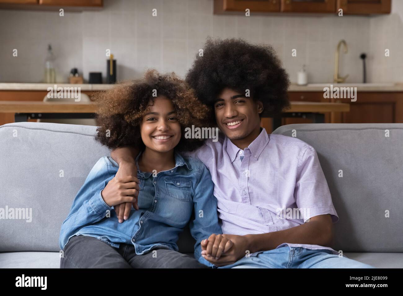 Afrikanische Freundin und Freund sitzen auf der Couch Blick auf die Kamera Stockfoto
