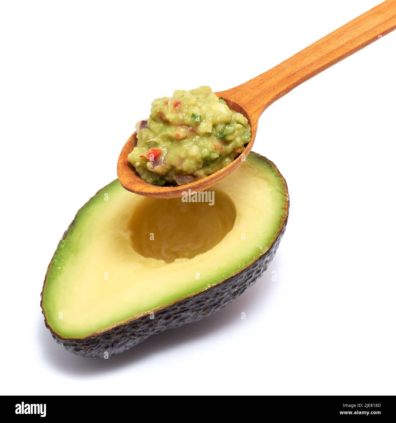 Holzlöffel Guacamole Dip Sauce und eine Hälfte Avocado isoliert auf weißem Hintergrund Stockfoto