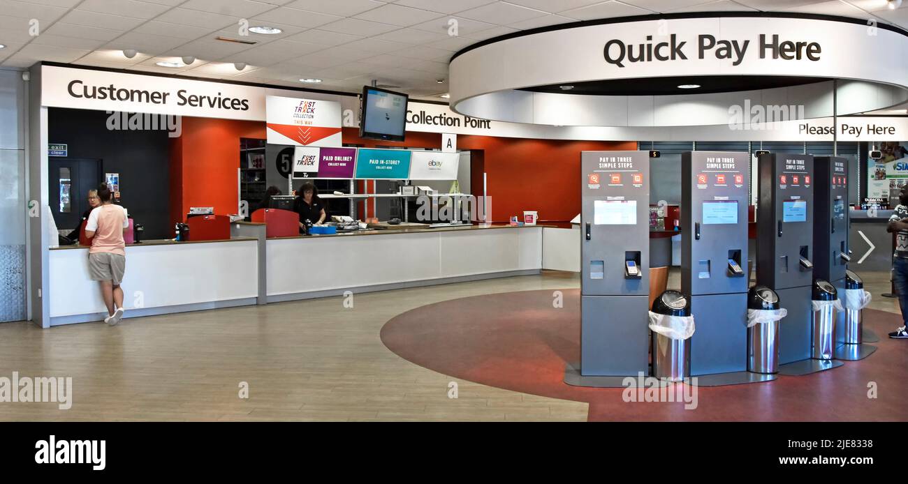 Argos Katalog Innenansicht der Person an der Kundendienstabstheke mit Abholstellen in der Nähe und Quick Pay Kassen in London England UK Stockfoto