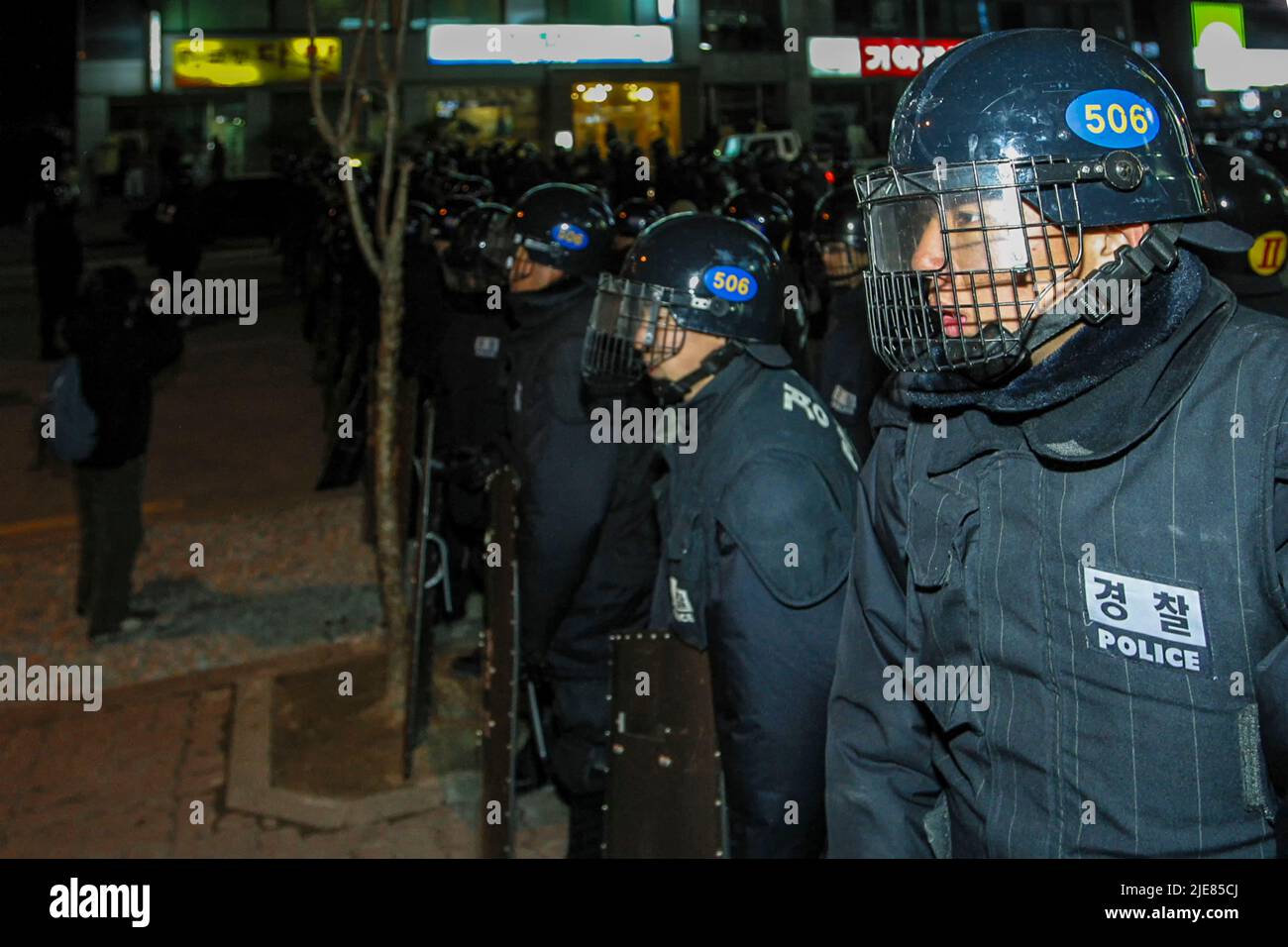 24. Nov 2003-Buan, Südkorea-Riot polizeibeamte kontrollieren die Straße in der Innenstadt von Buan-Gun, Südkorea. Das Ministerium für Handel, Industrie und Energie wählt eine kleine Insel vor Buan, einem Landkreis in der Provinz Nord-Jeolla, als Standort für eine nukleare Abfallentsorgungsanlage aus. Das Projekt brach jedoch aufgrund des starken Widerstands der Einwohner von Buan im Jahr 2004 zusammen. Die Regierung beschloss im Mai 2004, Anträge von regionalen Behörden zu erhalten, die die Fazilität als Gegenleistung für finanzielle Vorteile akzeptieren möchten. Stockfoto