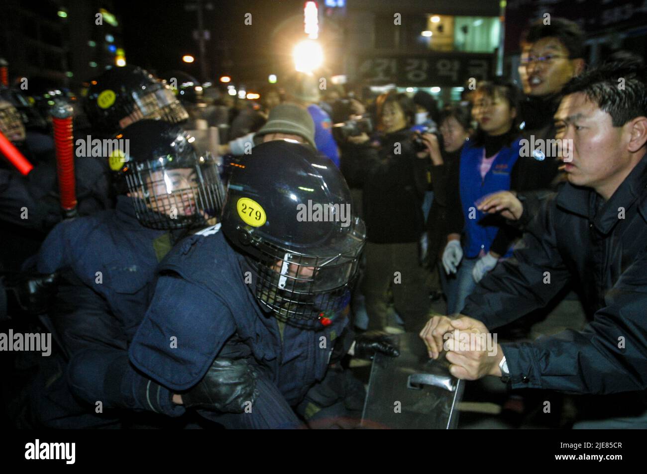 24. Nov 2003-Buan, Südkorea-die Menschen rufen mit Druck, um den Polizeischutz auf der Straße in der Innenstadt von Buan-Gun, Südkorea, anzurufen. Das Ministerium für Handel, Industrie und Energie wählt eine kleine Insel vor Buan, einem Landkreis in der Provinz Nord-Jeolla, als Standort für eine nukleare Abfallentsorgungsanlage aus. Das Projekt brach jedoch aufgrund des starken Widerstands der Einwohner von Buan im Jahr 2004 zusammen. Die Regierung beschloss im Mai 2004, Anträge von regionalen Behörden zu erhalten, die die Fazilität als Gegenleistung für finanzielle Vorteile akzeptieren möchten. Stockfoto