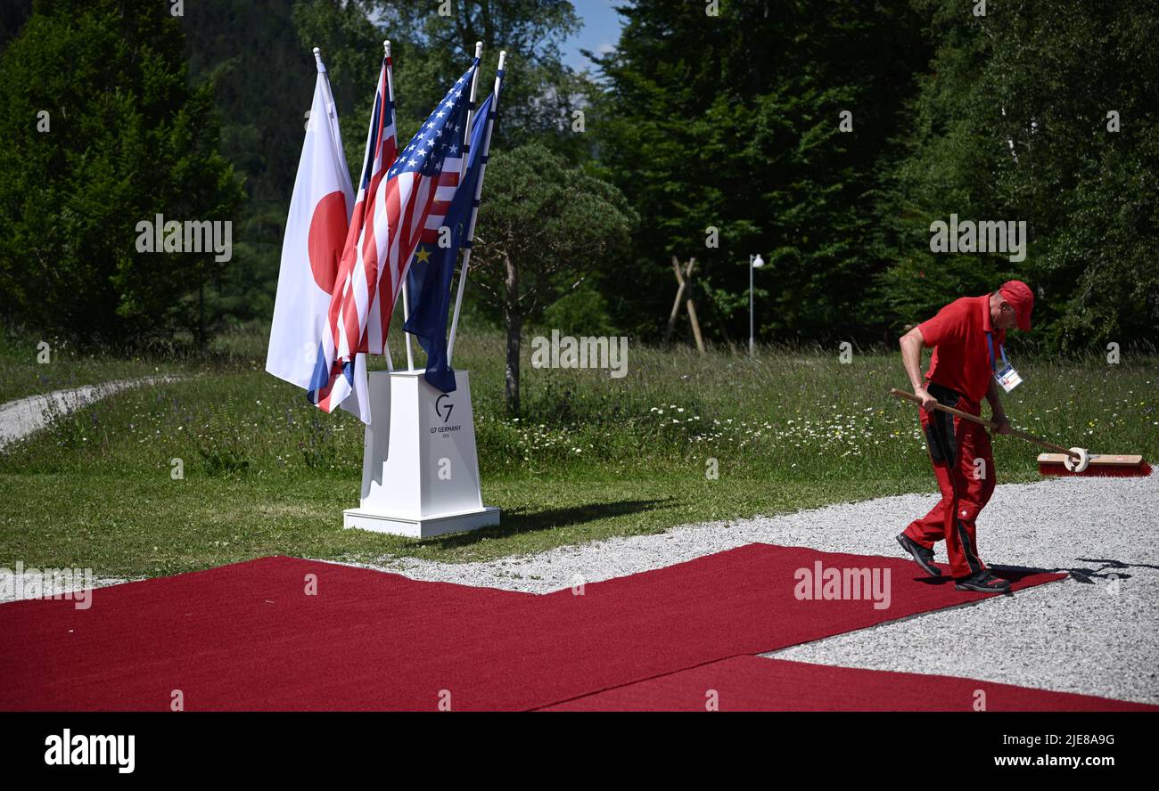 Ein Arbeiter putzt den roten Teppich an einem Willkommensort vor dem Gipfel der Staats- und Regierungschefs G7 auf Schloss Elmau, in Elmau, Bayern, am 26. Juni, 2022. Brendan Smialowski/Pool via REUTERS Stockfoto