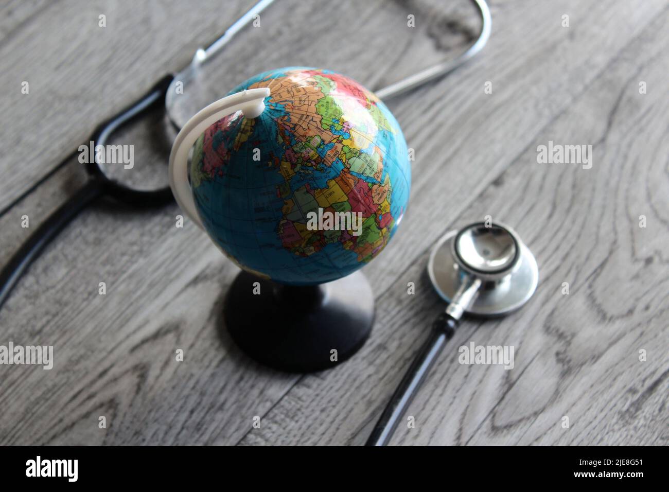 Weltgesundheitstag, Globale Gesundheitsversorgung, Medizinisches Konzept. Stethoskop und Erdkugel auf Holztisch. Stockfoto