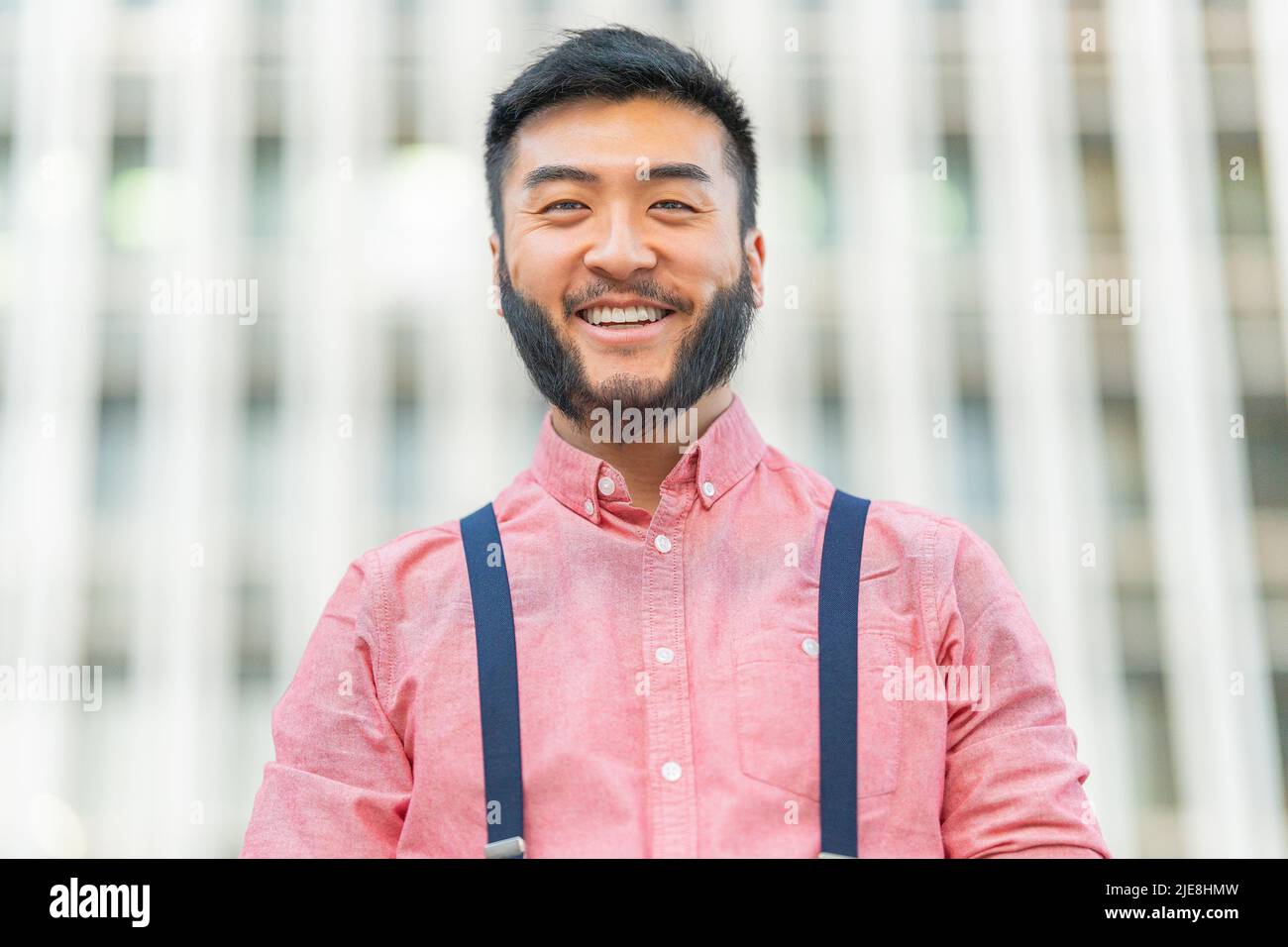 Nahaufnahme eines asiatischen Mannes, der draußen lächelt Stockfoto