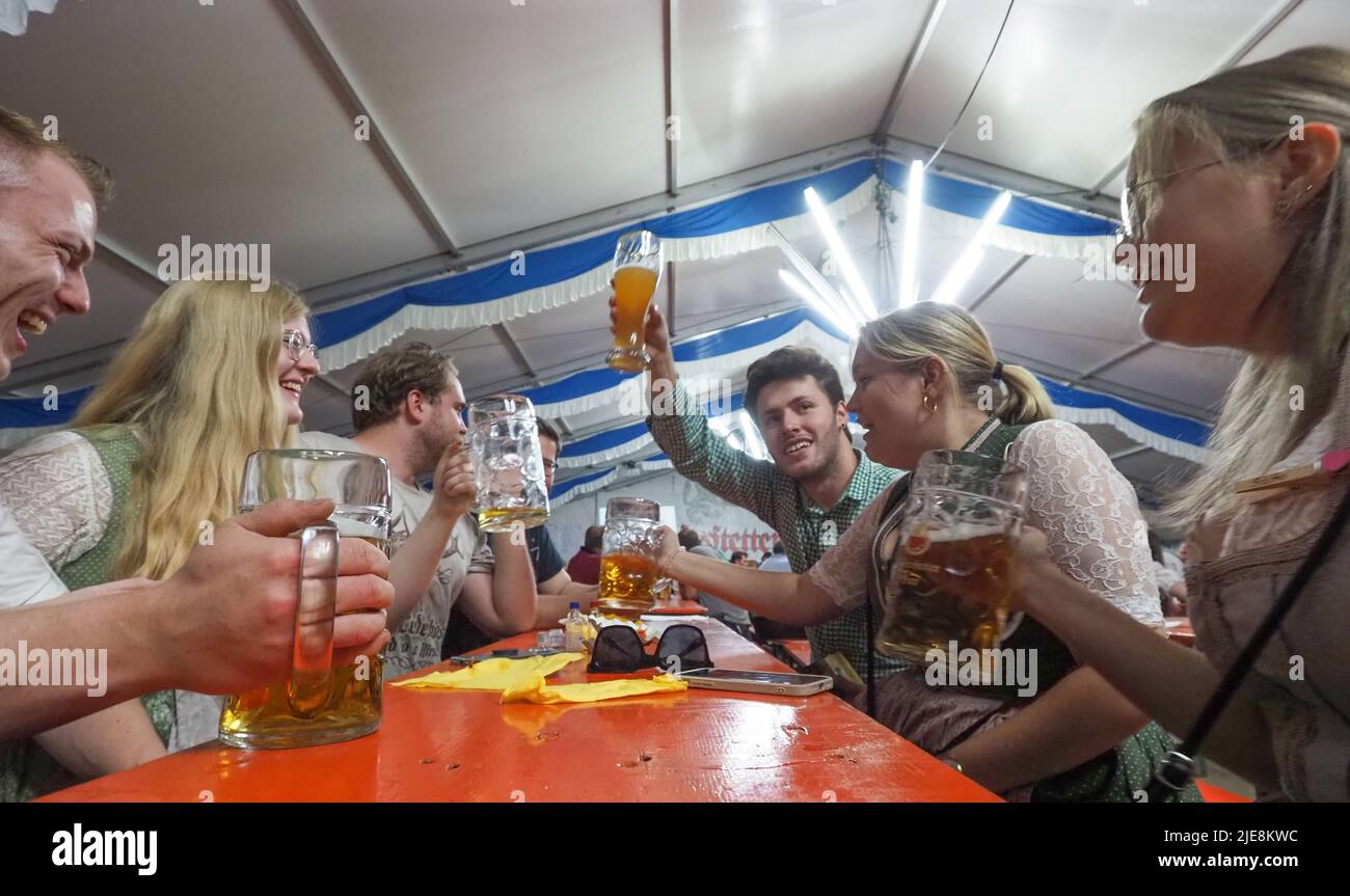 Freunde haben Spaß an der Aufführung eines ländlichen Orchesters, das Bier in Literbecher konsumiert. Während der Aussperrung der Epidemie scheinen die Deutschen alle möglichen gemeinsamen Zeitvertreibe verpasst zu haben. Jetzt, fast jede Woche, finden hier Festivals aus verschiedenen Städten statt, die in einem beispiellosen Ausmaß stattfinden. Das Volksfest versammelte sich in einer Einöde nahe der Dorfkirche fast die gesamte Bevölkerung der Alten. Die Menschen kommunizieren glücklich, trotz des unterschiedlichen Alters. Stockfoto