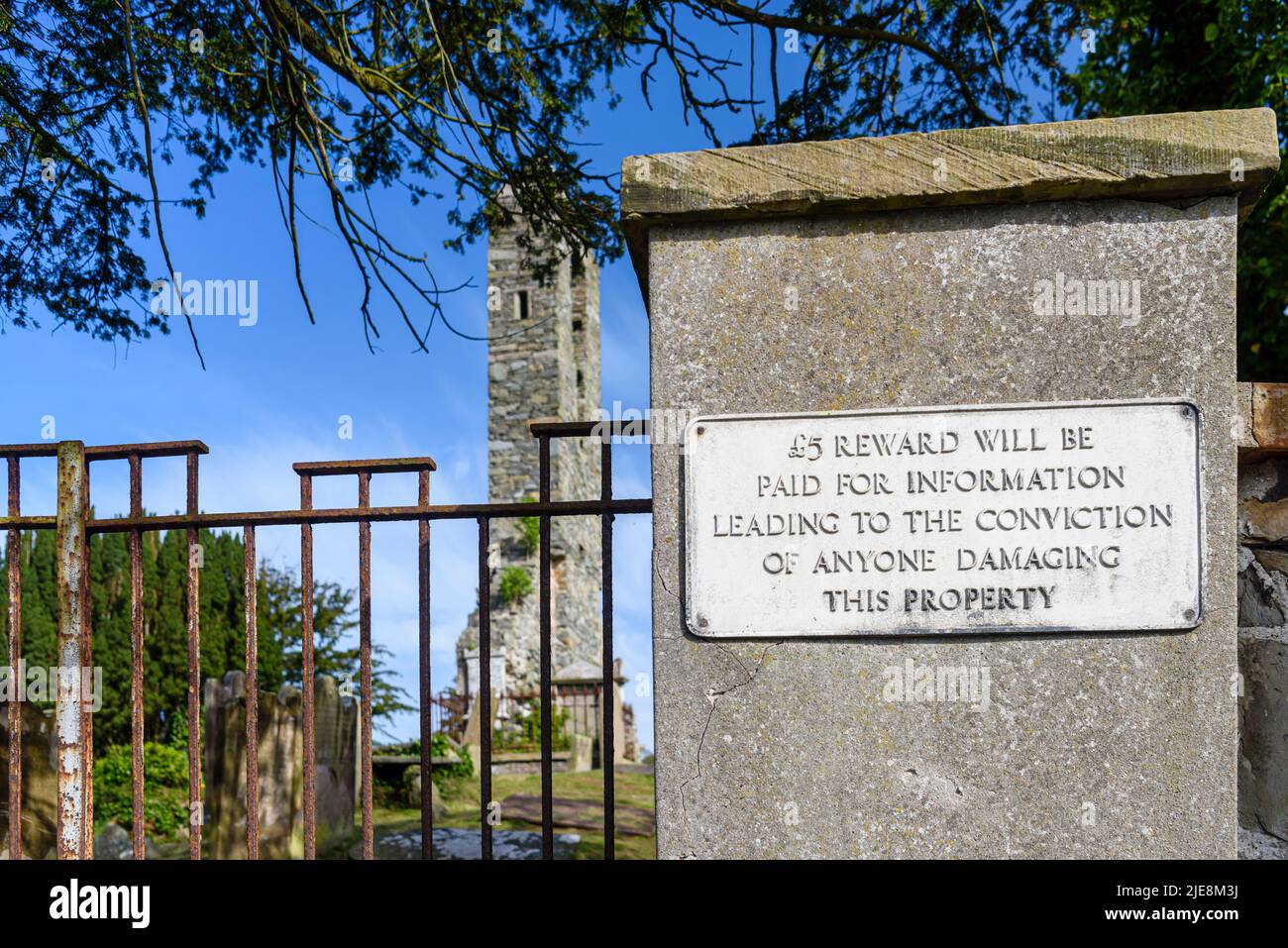 Ein gusseisernes Schild am Pfosten vor einer Kirche in Portaferry, das eine Belohnung von £5 für Informationen anbietet, die zur Verurteilung von Personen führen, die Schaden anrichten Stockfoto