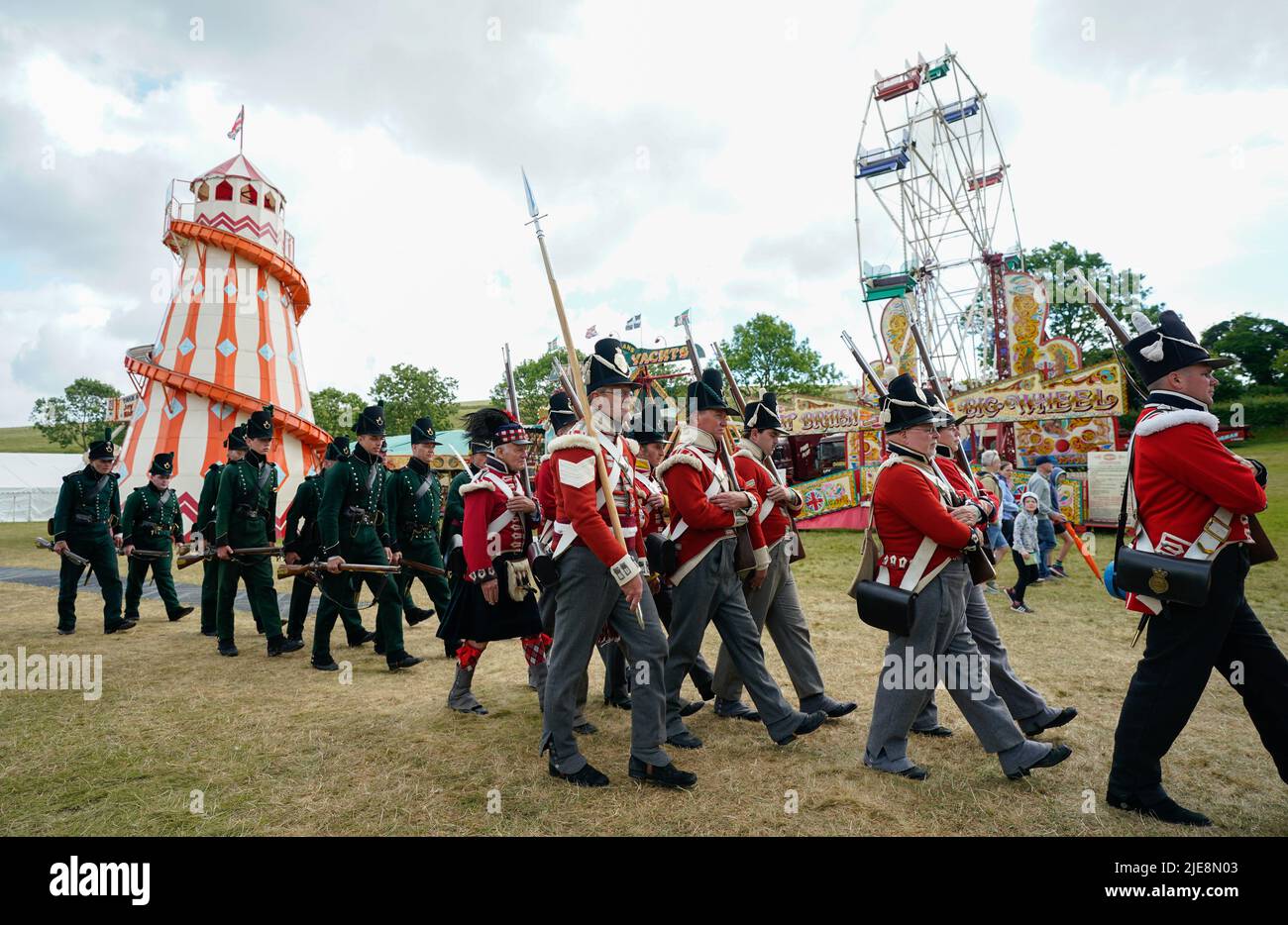 Mitglieder des 4. King's Own Regiment of Foot und des Bataillon 2. 9. Gewehre ziehen während des Chalke Valley History Festivals in Broad Chalke, in der Nähe von Salisbury, Wiltshire, um das Festivalgelände. Bilddatum: Sonntag, 26. Juni 2022. Stockfoto