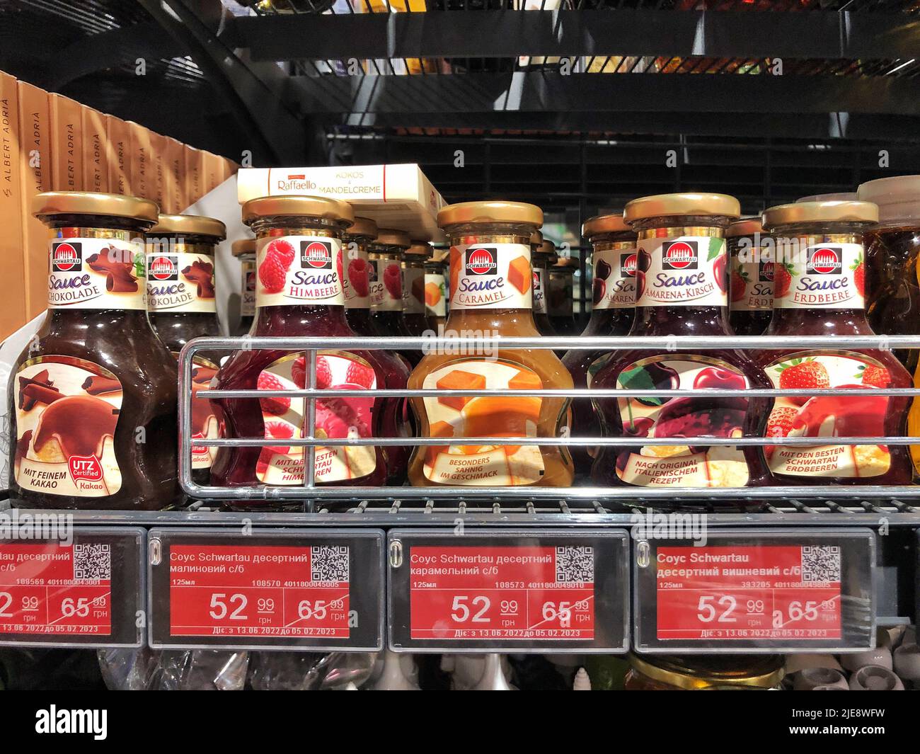 23.06.2022, Ukraine, Kharkov, Lebensmittelgeschäft. Eine große Auswahl an Dessert süßen Saucen in einer Glasflasche Stockfoto