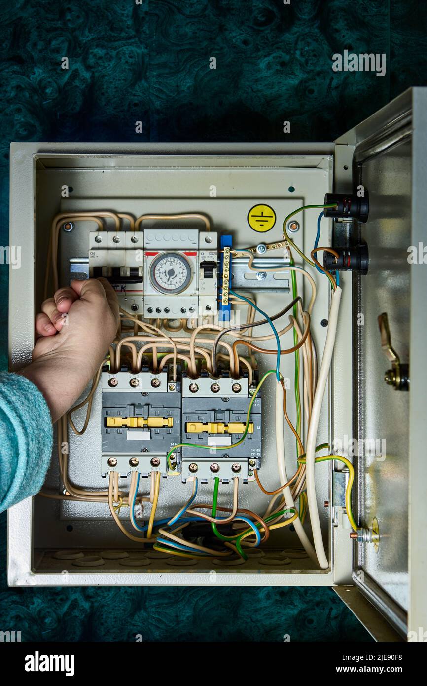 Mechanischer analoger Zeitschalter zur Steuerung von Pumpen und Heizung in Echtzeit, der sich in der Schalttafel befindet. Stockfoto