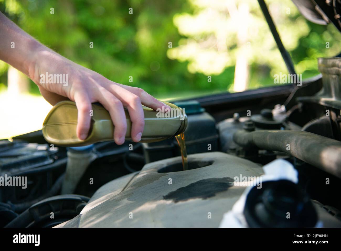 Nahaufnahme Hand Mechaniker Reparatur wechseln das Öl. Kfz-Mechaniker gießt frisches Öl in die Motorreparatur an der Tankstelle. Stockfoto