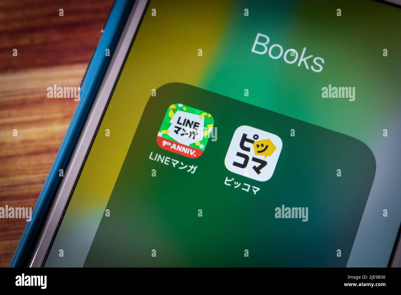 Kumamoto, JAPAN - Jun 23 2022 : Piccoma und LINE Manga Apps auf dem iPhone auf Holztisch in dunkler Stimmung. Japanisches Online-Manga-Abo-Service-Konzept Stockfoto