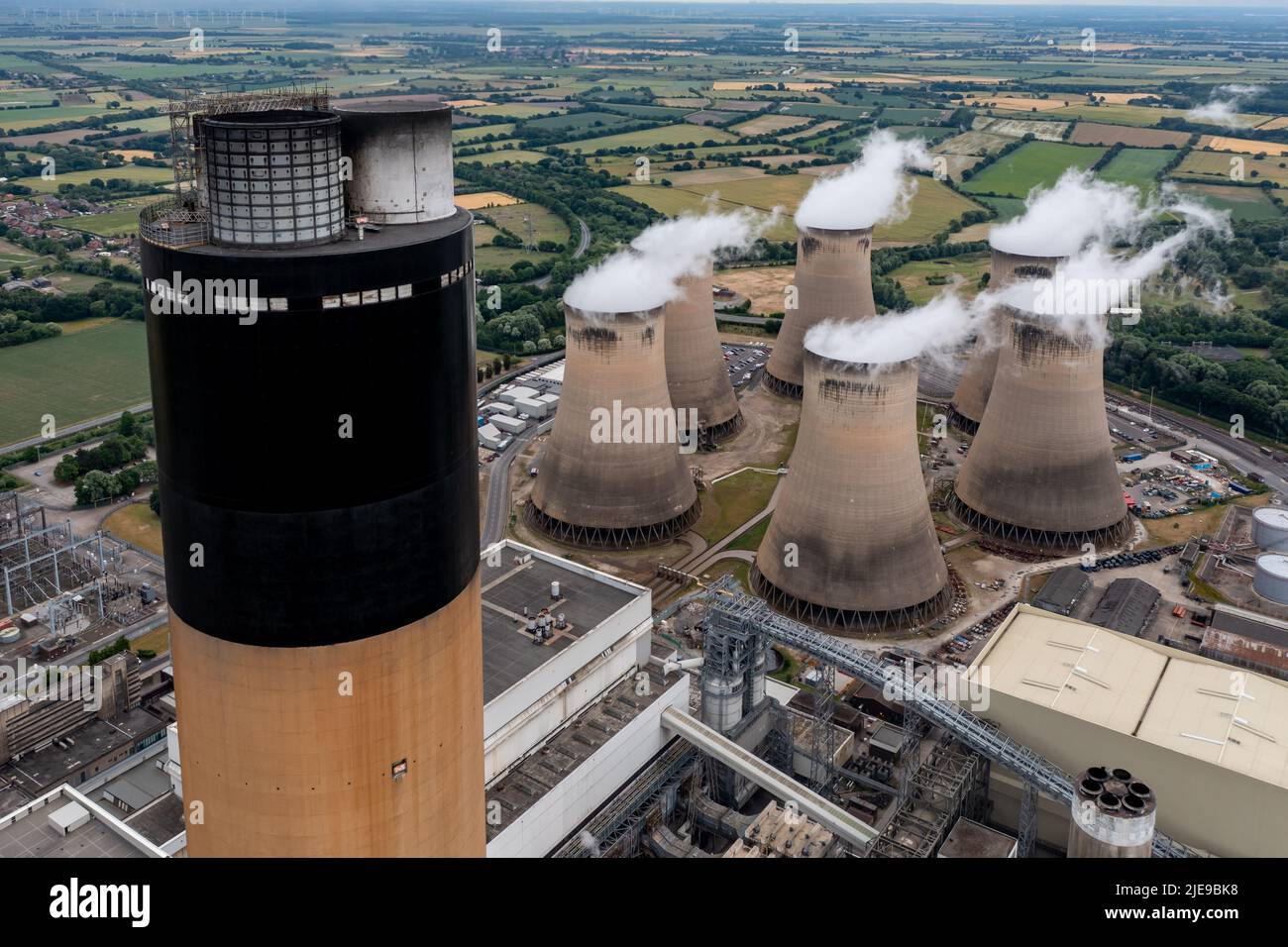 Luftaufnahme auf der Spitze eines hohen Schornsteins in einem Kohlekraftwerk in einem Konzept für Luftverschmutzung und Kohlendioxidemissionen mit Kopierraum Stockfoto