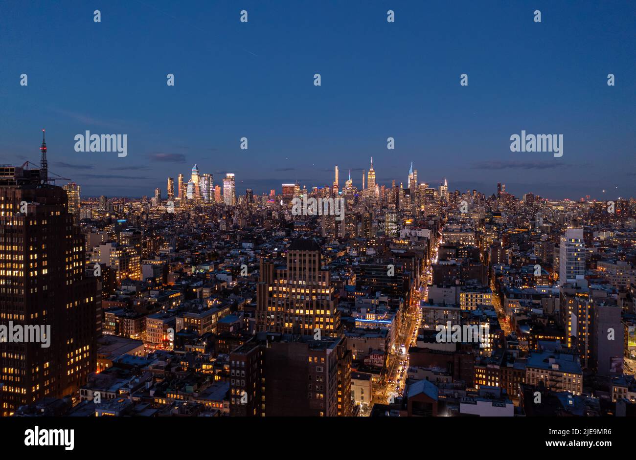 Panoramaaufnahme der Metropole nach Sonnenuntergang. Die Gipfel der Wolkenkratzer in der Innenstadt sind von letzten Sonnenstrahlen erleuchtet. Manhattan, New York City, USA Stockfoto
