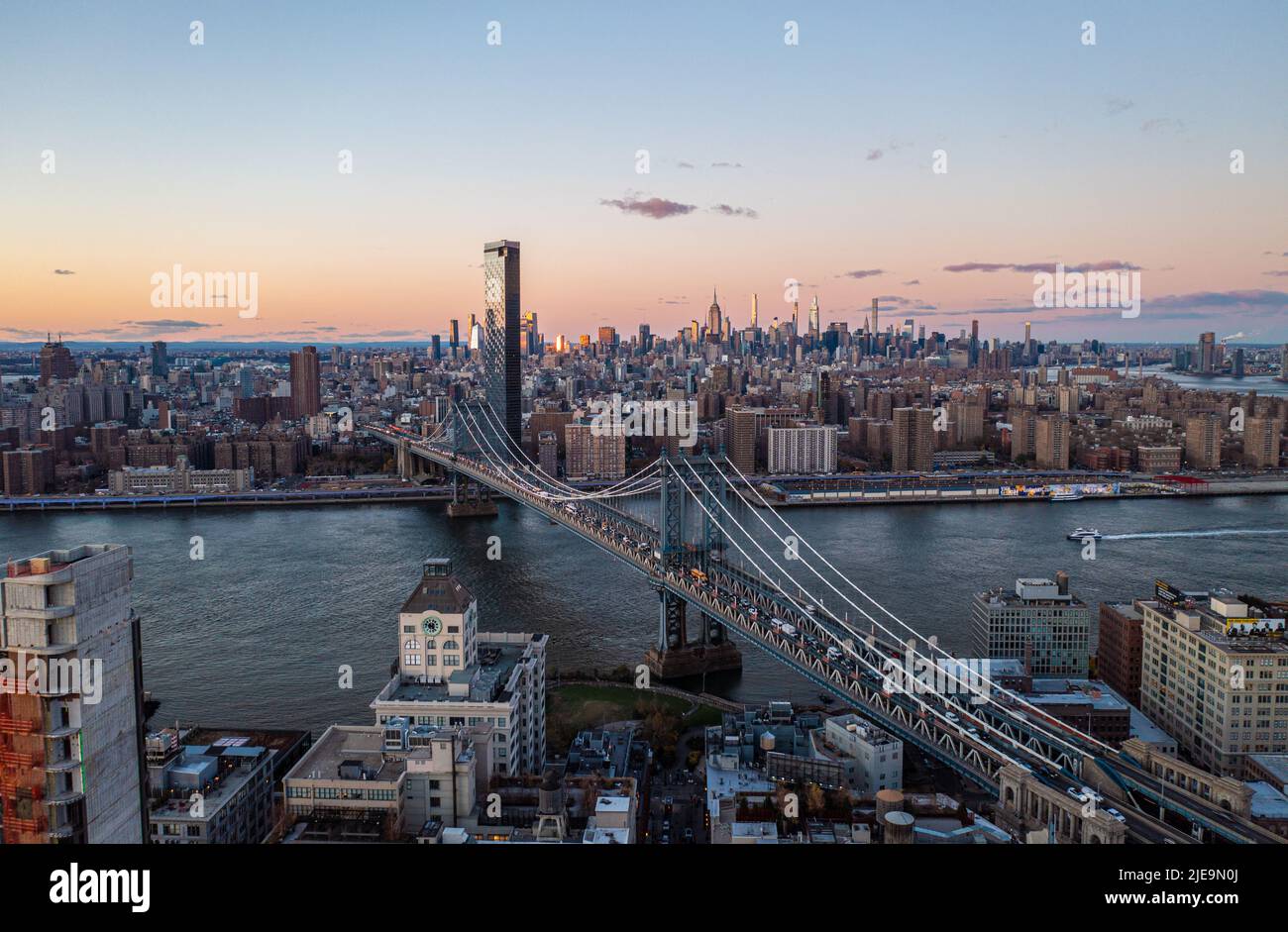 Berühmte Kabel blieben Manhattan Brücke über East River in der Dämmerung. Stadtbezirke und Wolkenkratzer in der Innenstadt in der Ferne. Manhattan, New York City, USA Stockfoto