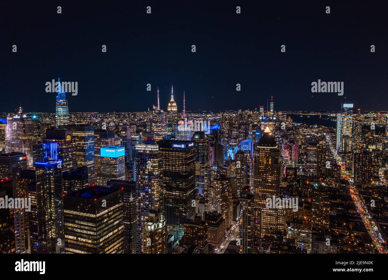 Luftpanorama der Metropole bei Nacht. Farbenfrohe Neonlichter an Hochhäusern in Stadtbezirks. Manhattan, New York City, USA Stockfoto
