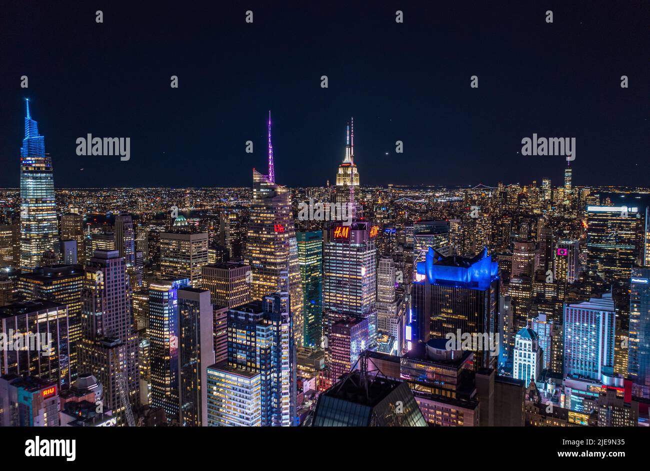 Nächtliche Stadtszene mit hohen Wolkenkratzern in der Innenstadt in der Metropole. Hohe Gebäude mit farbigen beleuchteten Türmen auf den Gipfeln. Manhattan, New York City, USA Stockfoto