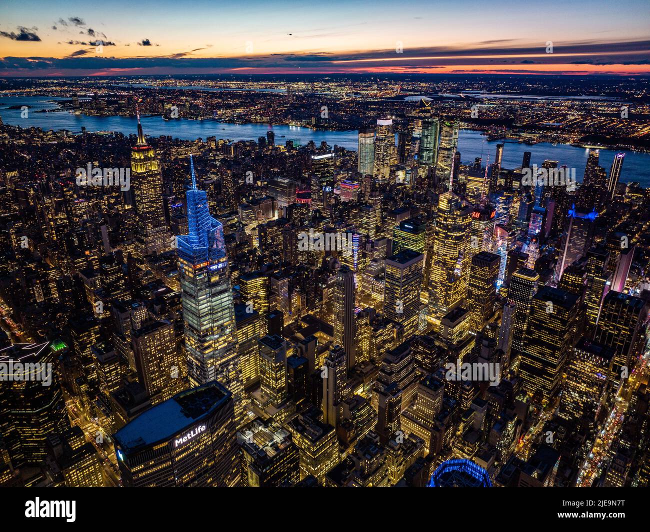 Abendliches Stadtpanorama. Beleuchtete Hochhäuser im Stadtzentrum und farbiger Abendhimmel im Hintergrund. Manhattan, New York City, USA Stockfoto