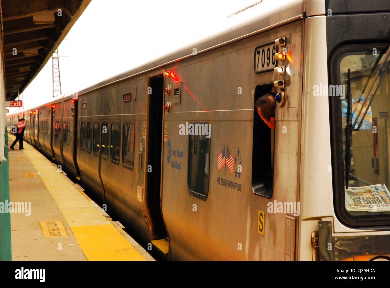 Ein Schaffner blickt zurück, während ein Pendler auf seinen Long Island Railroad-Zug zufährt, bevor die Türen schließen Stockfoto