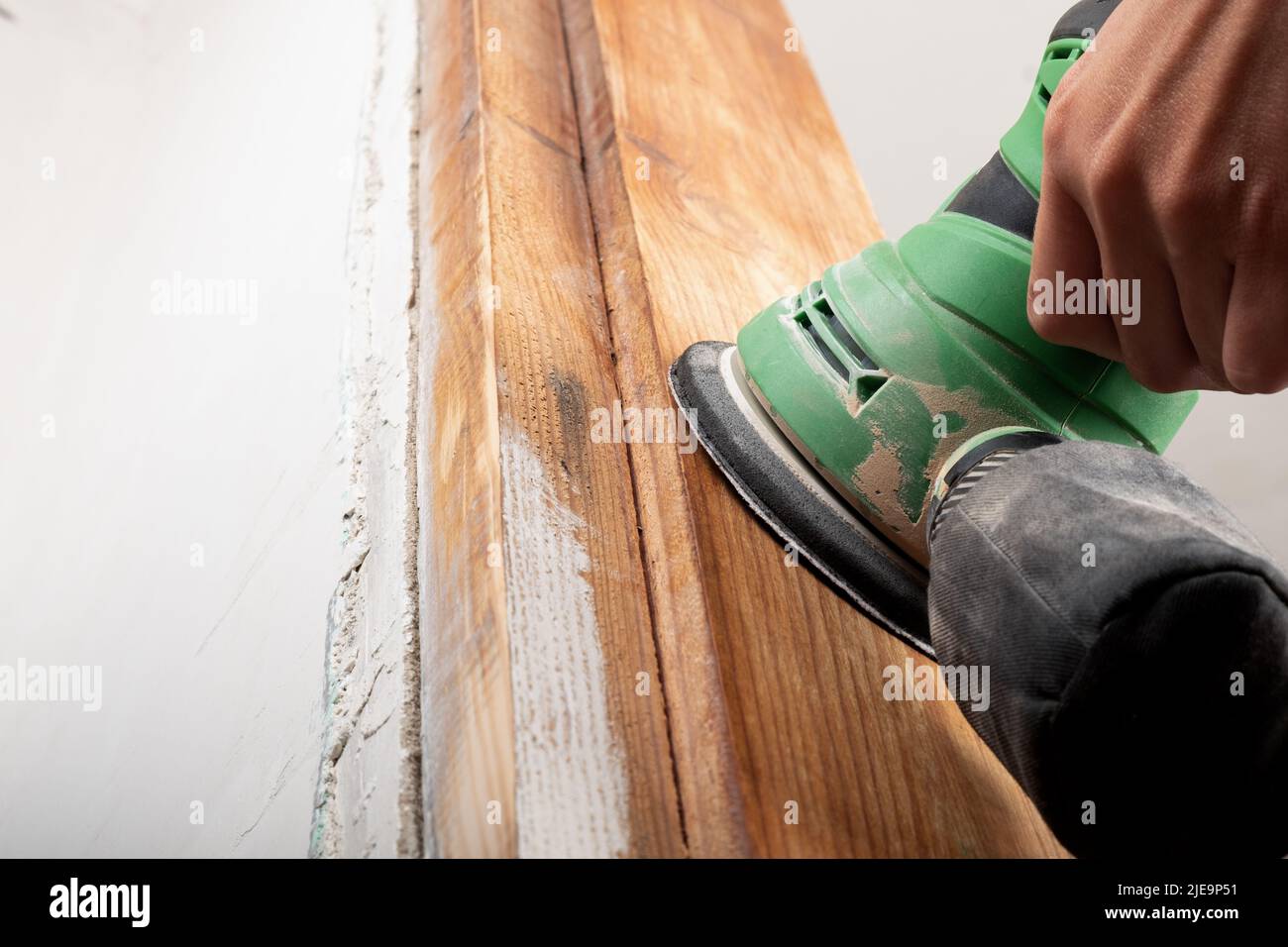 Entfernen des Lackes aus dem Holz, Bearbeiten und Polieren des Holzes mit dem Schleifer. Stockfoto