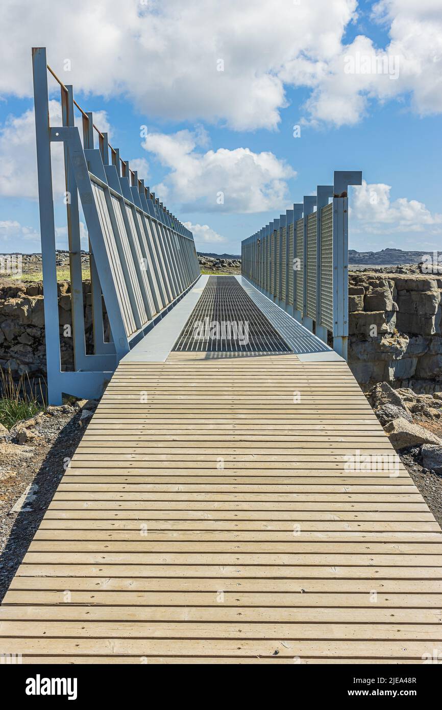 Querschnitt einer Metallbrücke in Island auf der Halbinsel Reykjanes. Brücke über eurasische und nordamerikanische Gräben. Holzrampe zur Brücke mit l Stockfoto