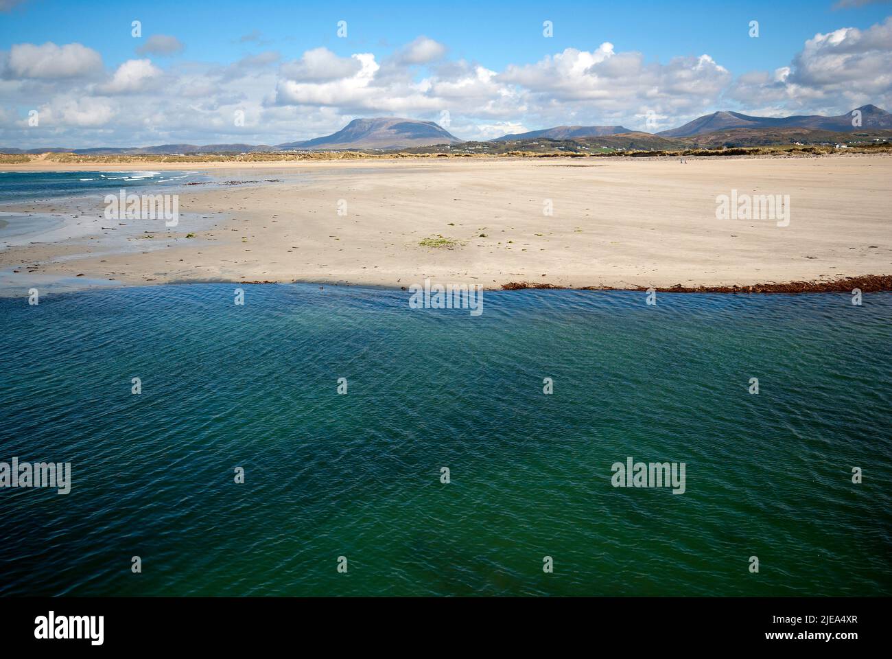 Magheroarty Beach mit Ebbe und der flachen Silhouette des Mount Muckish (Derryveagh Mountains) im Hintergrund, County Donegal, Irland Stockfoto