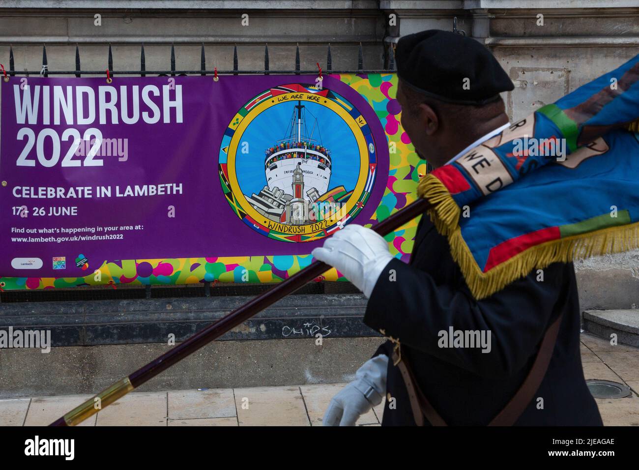 London, Großbritannien. 26.. Juni 2022. Ein Servicepersonal der West Indian Association geht an einem Banner mit der Aufschrift „Windrush 2022“ auf dem Windrush Square vorbei. Die Windrush-Generation besteht aus karibischen Einwanderern und ihren Verkommenen, die am 22.. Juni, dem Tag, an dem HMT Empire Windrush 1948 an den Tilbury Docks ankam, an die Küsten Großbritanniens kamen. Kredit: SOPA Images Limited/Alamy Live Nachrichten Stockfoto