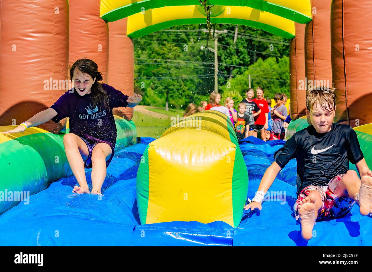 Kinder spielen am 27. Juli 2012 auf einer aufblasbaren Wasserrutsche in Columbus, Mississippi. Stockfoto
