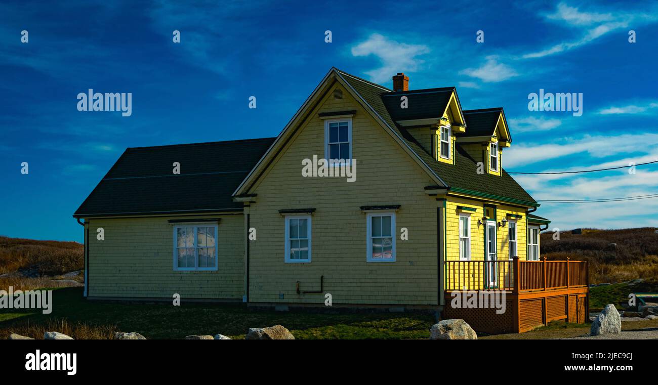 Altes kleines gelbes Haus in peggys Cove Nova scotia, das an einem warmen Frühlingstag in der Sonne baden kann Stockfoto