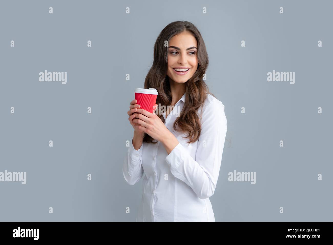 Schöne junge Frau genießt eine Tasse Kaffee beim Entspannen. Menschen, Getränke und Freizeit, glückliche junge Frau mit einer Tasse Tee oder Kaffee. Stockfoto
