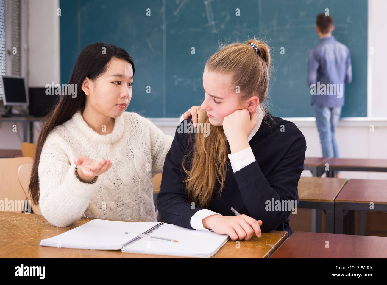 Asiatische Mädchen beruhigende weibliche Freundin studieren im Klassenzimmer Stockfoto