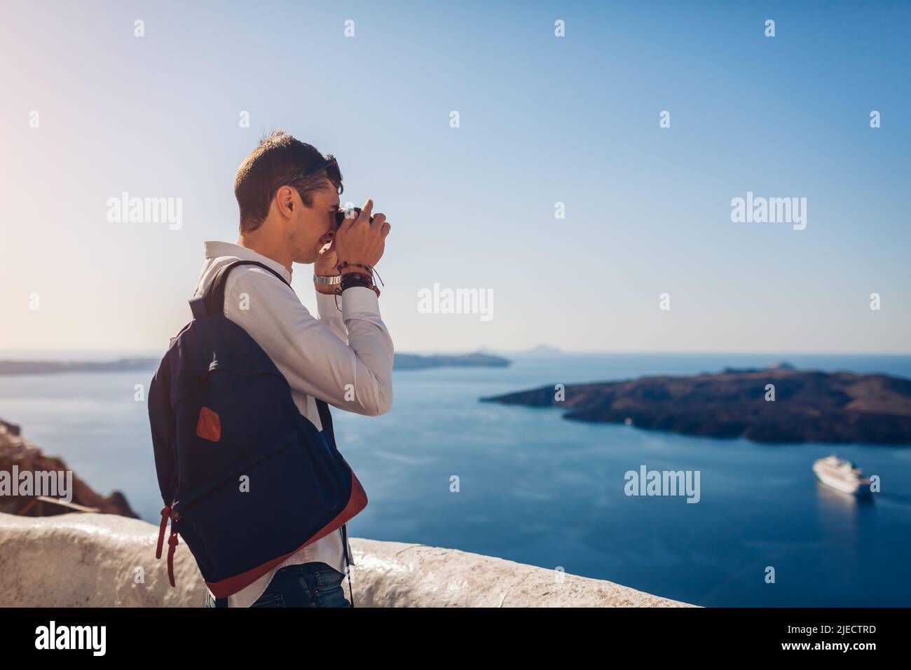 Santorini Reisender Mann fotografiert Caldera aus Fira oder Thera, Griechenland mit der Kamera. Tourismus, Reisen, Urlaub Stockfoto Santorini Reisender Mann fotografiert Caldera aus Fira oder Thera, Griechenland mit der Kamera. Tourismus, Reisen, Urlaub Stockfoto
