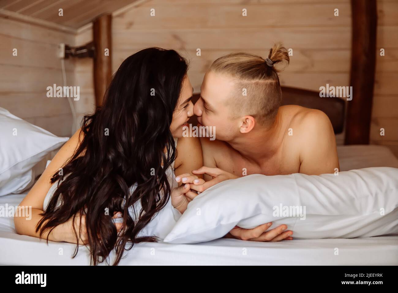 Ein liebevolles Paar im Bett lächelt, ist glücklich und verliebt. Stockfoto