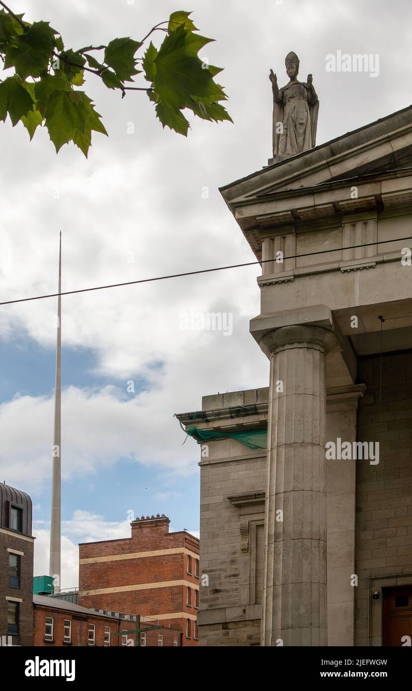 Dublin, Irland. Eine Skulptur auf dem Dach der St. Mary's Pro-Cathedral und des Spire of Dublin in der Ferne Stockfoto