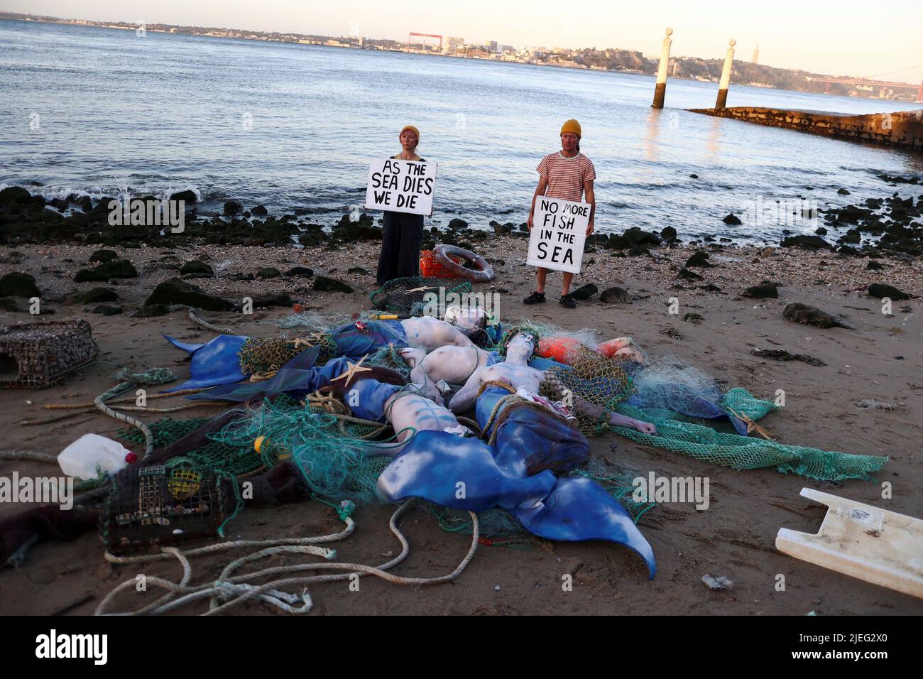 Am ersten Tag der UN-Ozeankonferenz am Strand von Cais das Colunas in Lissabon, Portugal, protestieren Aktivisten im Morgengrauen, um die Staats- und Regierungschefs der Welt zu drängen, alle nationalen Kraftstoffsubventionen für Fischereiflotten zu beenden. Der 27. Juni 2022. REUTERS/Pedro Nunes Stockfoto