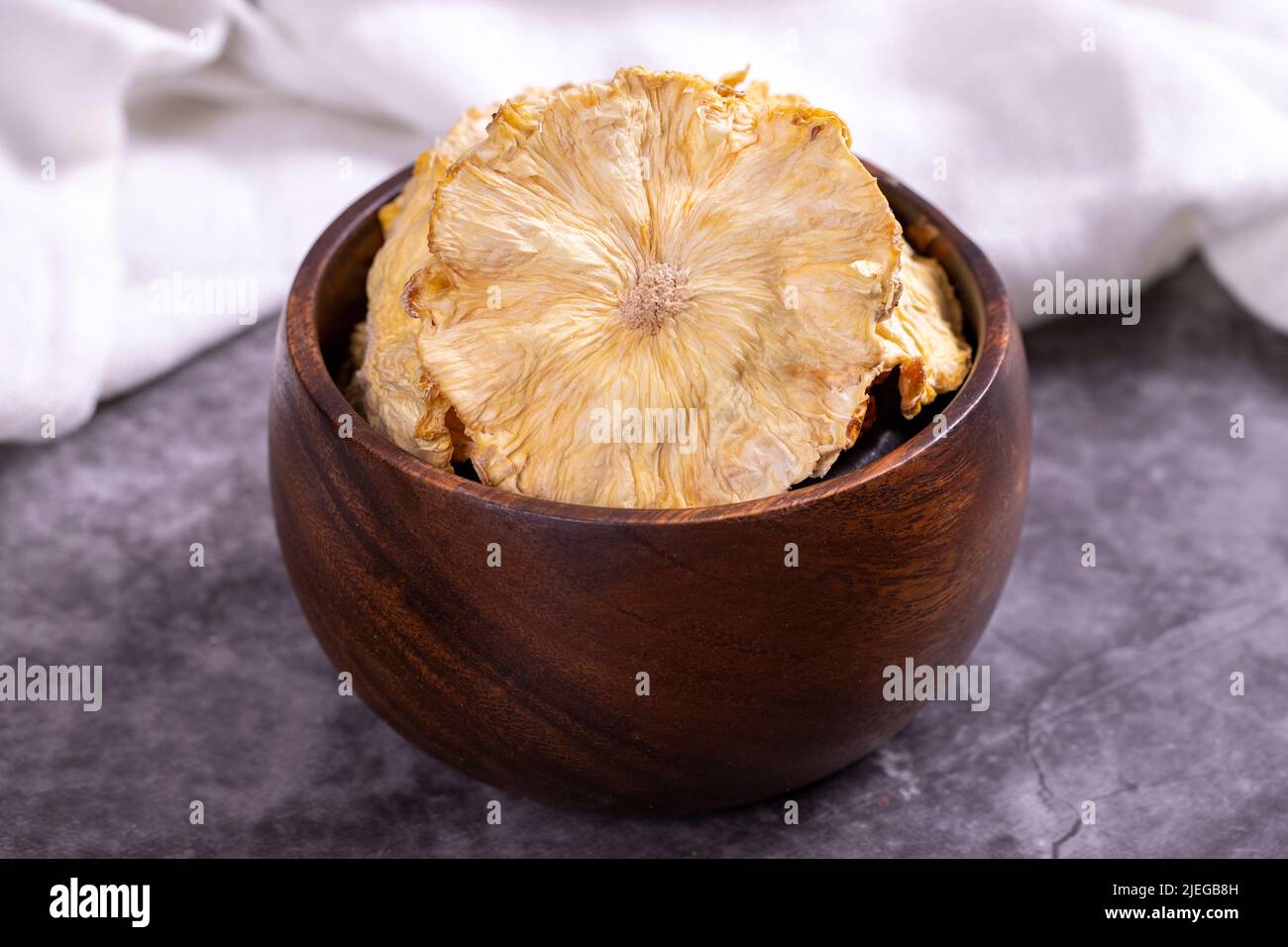 Getrocknete Ananasscheiben. Geschnittene getrocknete Ananas auf dunklem Hintergrund. Sonnengetrocknete Früchte. Nahaufnahme Stockfoto