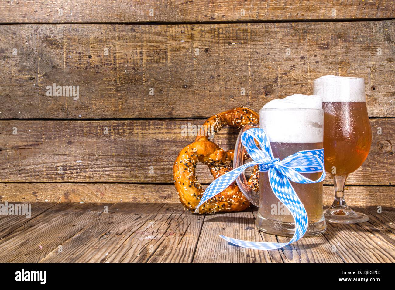 Oktoberfest verschiedene Biergläser und Becher mit Brezel, Weizen und Hopfen. Bar- und Pub-Menü, Einladungskarte im Hintergrund auf einem Kopierbereich mit Holzhintergrund Stockfoto