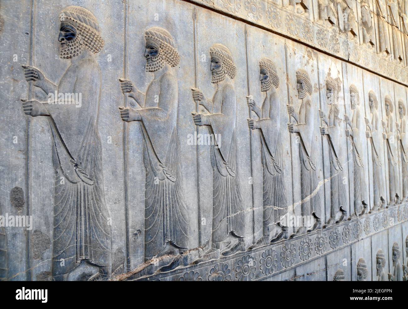 Alte Mauer mit bas-relief mit assyrischen Krieger mit Speeren, Persepolis, Iran. Weltkulturerbe der UNESCO Stockfoto